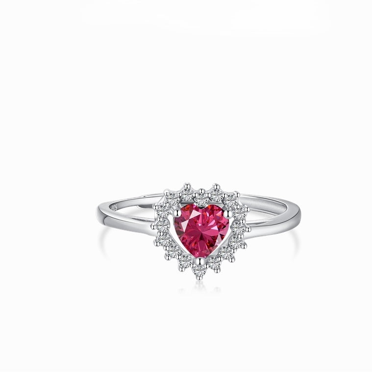 Anillo en tono plateado con una piedra rosa de corte corazón y un halo de pequeñas piedras transparentes
