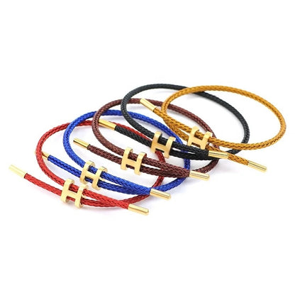 A product photo of five adjustable bracelets stacked on a white background. The bracelets have a minimalist design, with braided rope in various colors: red, blue, dark brown, black, and golden-yellow. Each bracelet features an adjustable gold-toned metal clasp in the shape of a capital 'H'.