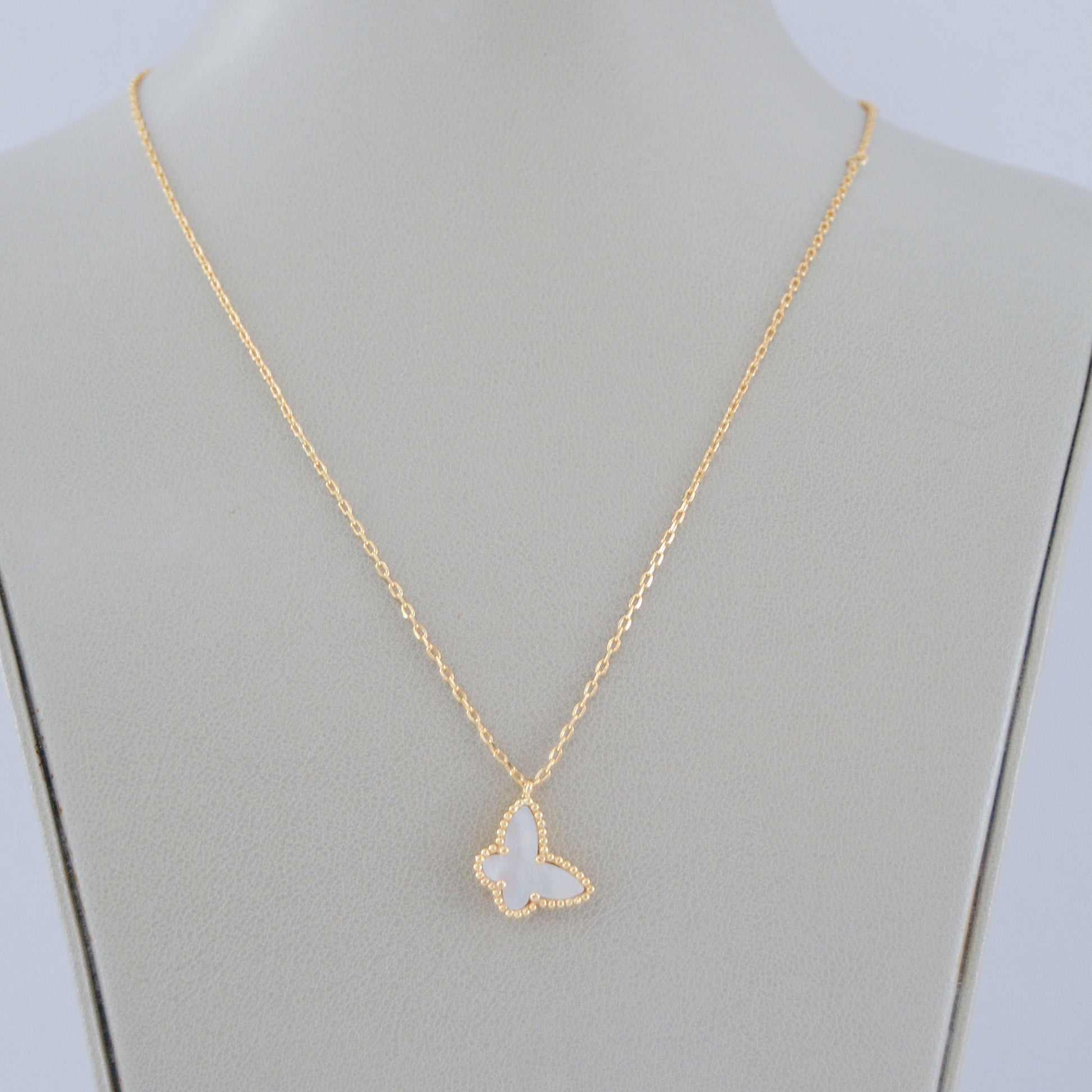Gargantilla de oro laminado con dije de mariposa blanca de madreperla. Collar delicado, ideal para layering y uso diario.