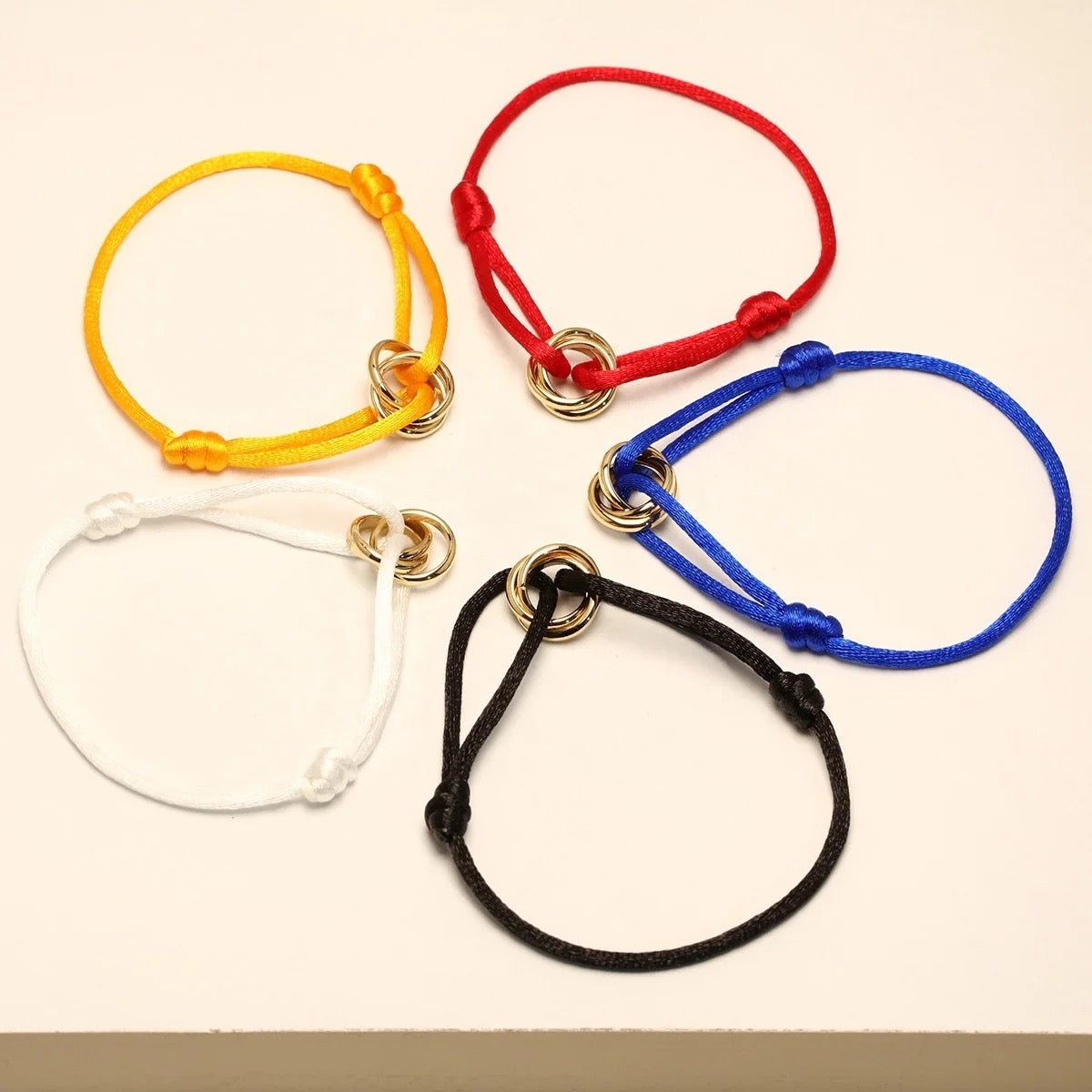 Adjustable cord bracelets with double gold rings in yellow, red, blue, white and black — MARO Jewelry.