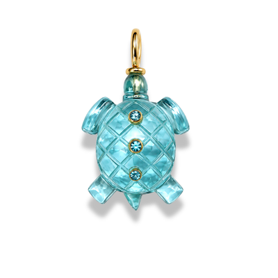 Dije de tortuga azul aguamarina con caparazón de aspecto acolchado, tres pequeñas piedras y una argolla en tono dorado