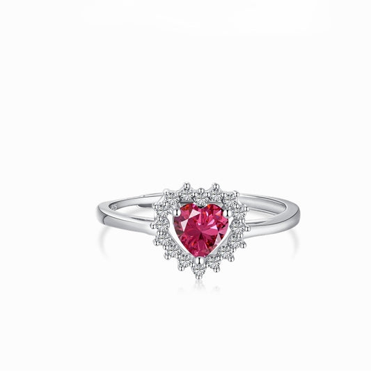 Anillo en tono plateado con una piedra rosa de corte corazón y un halo de pequeñas piedras transparentes