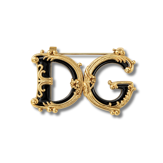 Broche de dos letras grandes negras brillantes con bordes de adornos en espiral en tono dorado, sobre fondo blanco
