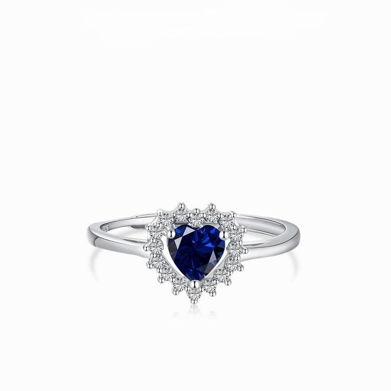 Anillo ajustable en tono plateado con una piedra azul intenso de corte corazón y un halo de piedras transparentes