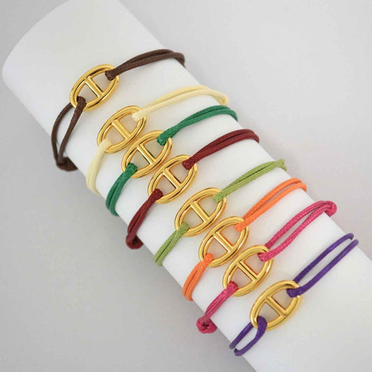 Conjunto de pulseras finas de cordón de colores en oliva, marrón, naranja, rojo y morado con eslabones centrales tono dorado