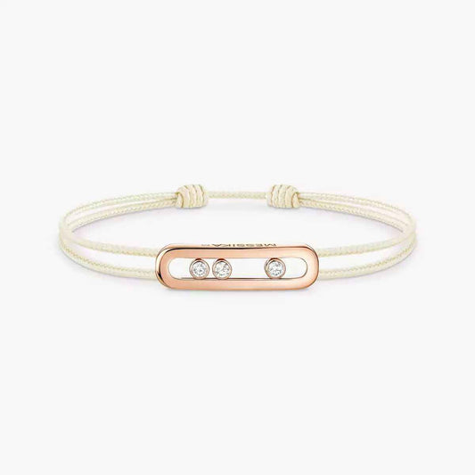 Cream double-cord bracelet with a rose gold-tone oblong plate set with three small clear stones, on white