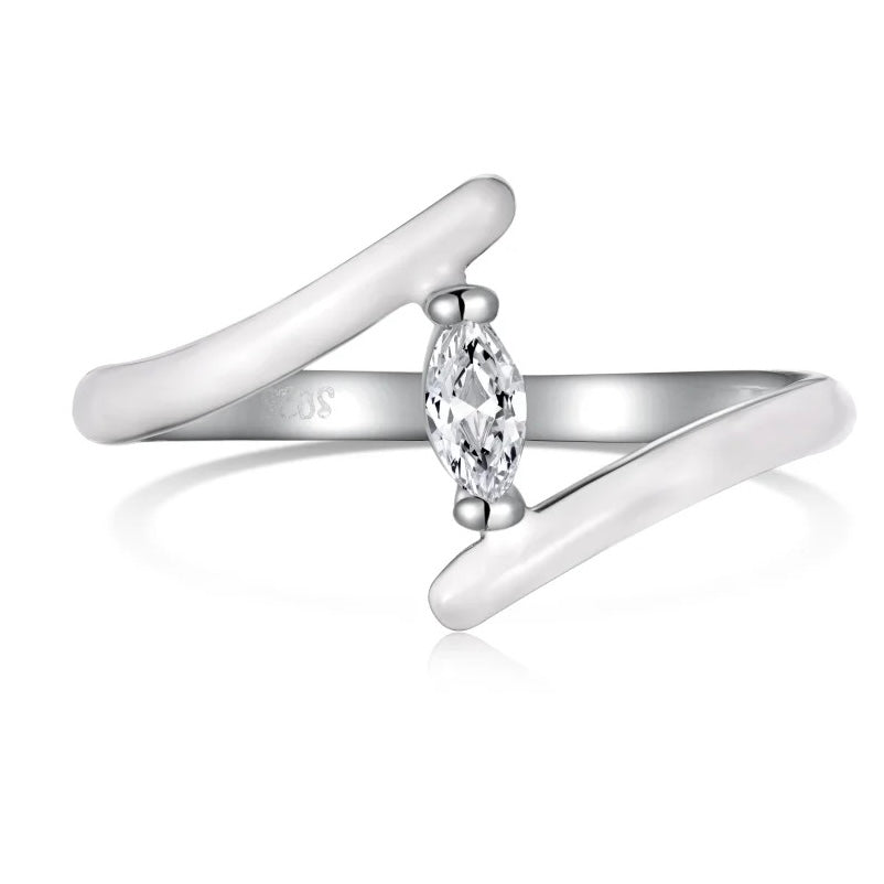 Anillo de tono plateado con dos extremos blancos brillantes que se superponen y una piedra transparente en forma de marquesa en el centro