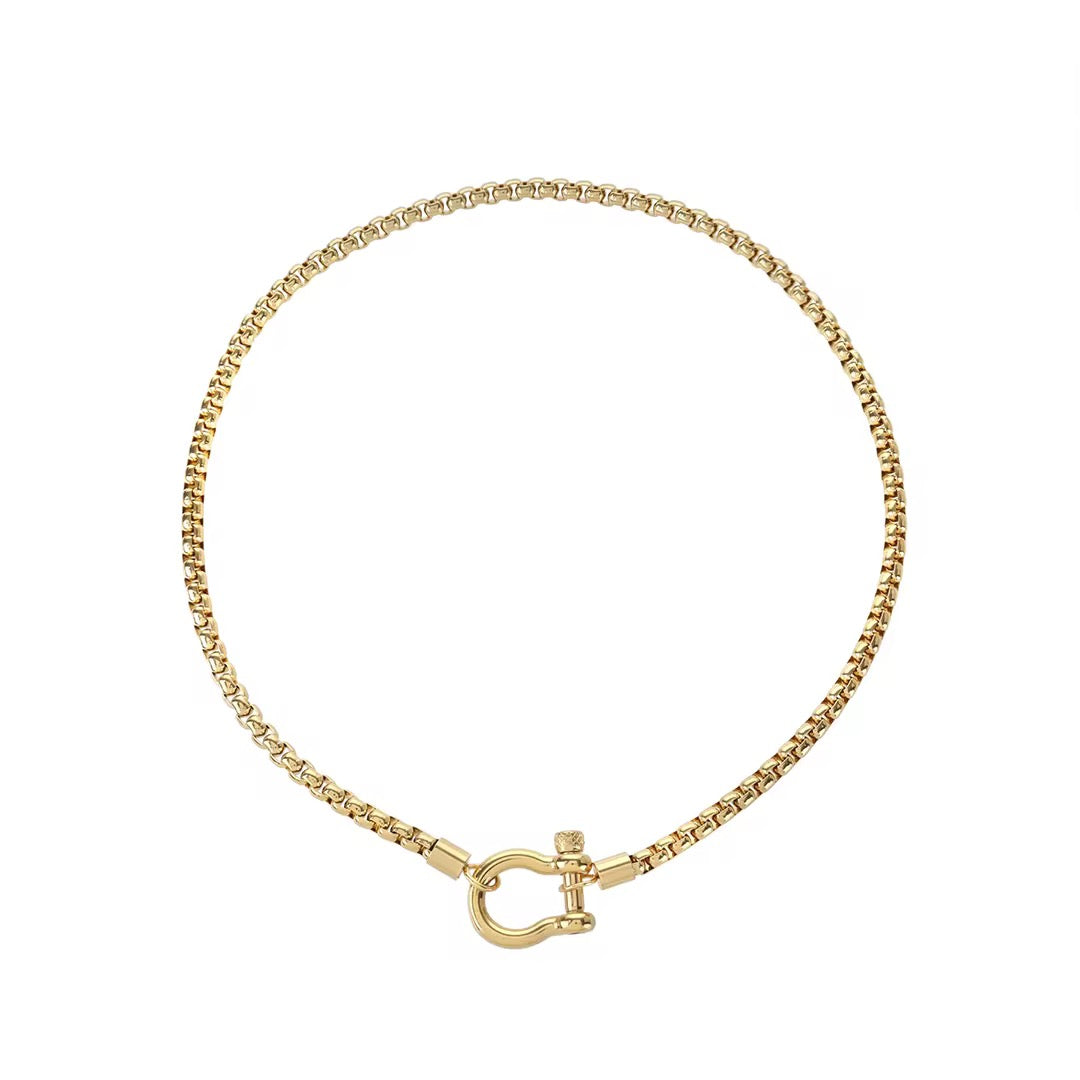 Collar de cadena de eslabones cuadrados de tono dorado con un cierre de grillete en forma de herradura al frente