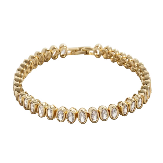 Tennis-style bracelet of oval clear stones in rounded gold-tone settings, flat on white