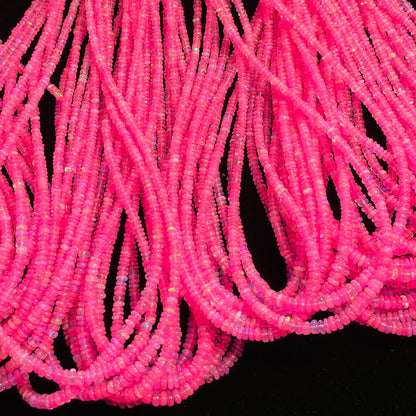 Muchas hebras de diminutas cuentas rosa fucsia amontonadas