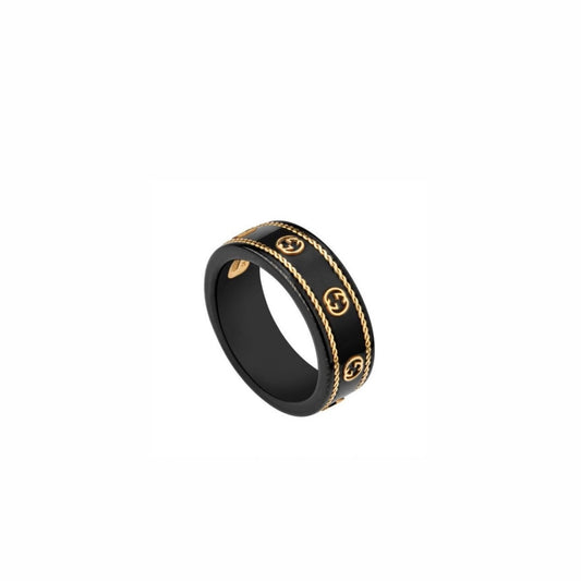 Anillo ancho negro brillante con bordes en tono dorado y un patrón entrelazado repetido