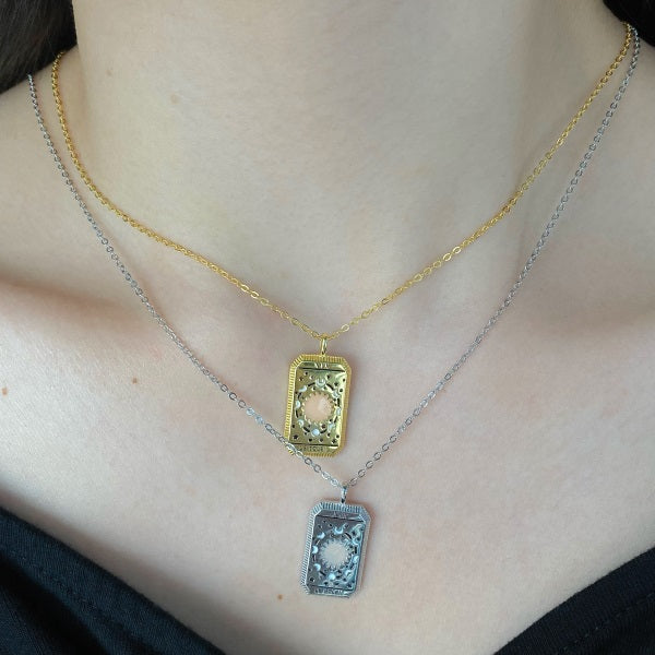 Silver-tone and gold-tone tarot-style pendants layered on a neck