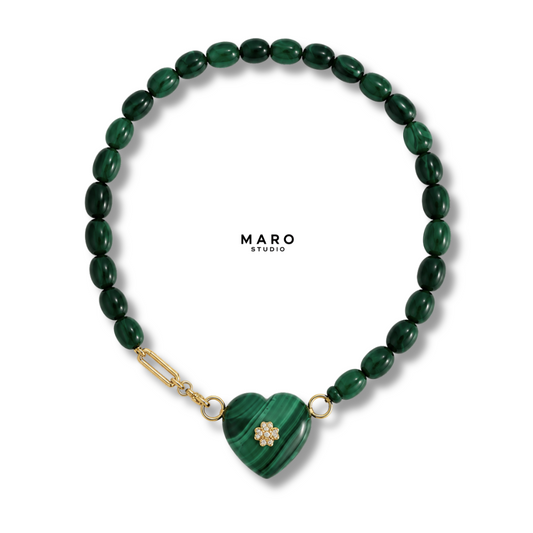 Collar de cuentas ovaladas verde oscuro con un corazón verde tallado y un pequeño trébol al frente