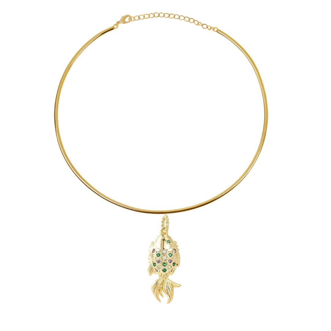 Rigid gold-tone choker with a small fish pendant set with green and clear stones, on white