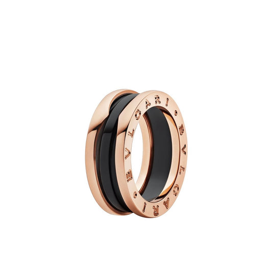 Rose gold-tone ring with a glossy black center band and engraved lettering