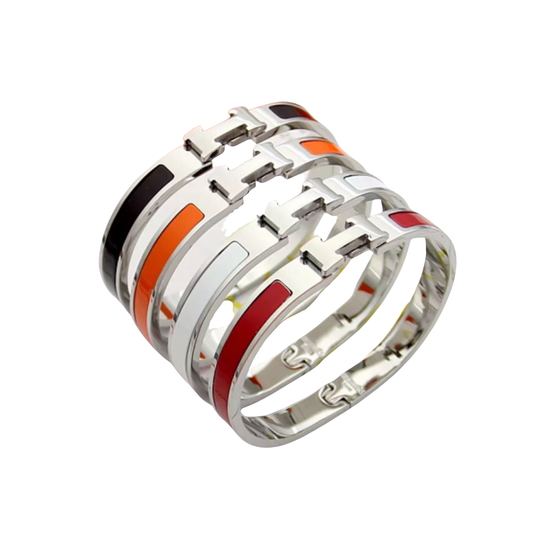 Conjunto de brazaletes de tono plateado con bandas de color brillantes en negro, blanco, naranja y rojo, y cierres en forma de H