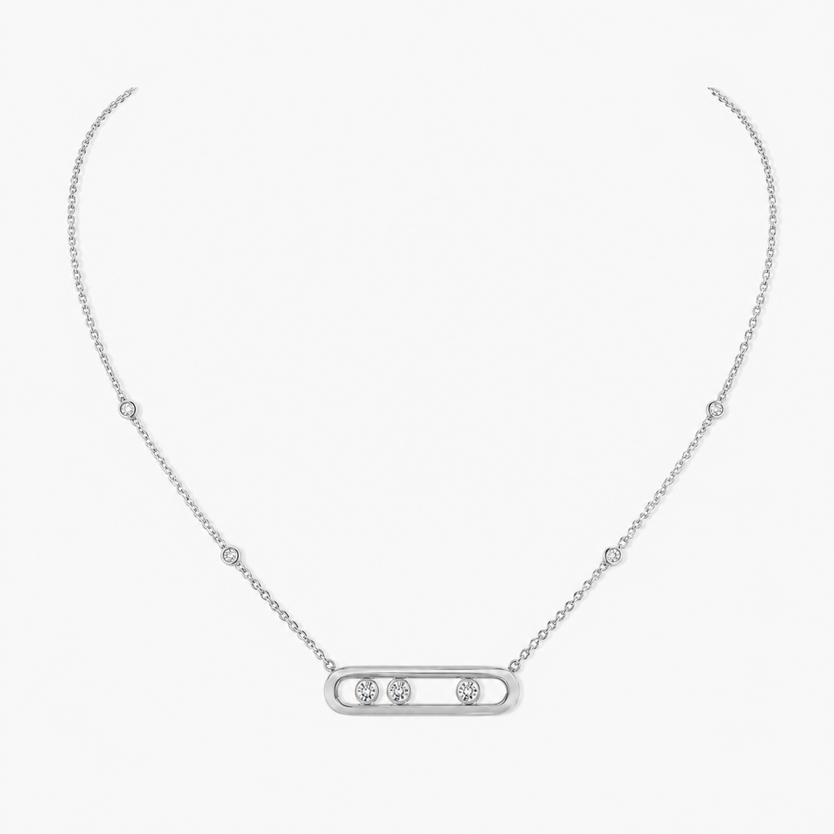 Silver-tone chain necklace with a slim oval pavé bar pendant holding three larger stones, on a light background