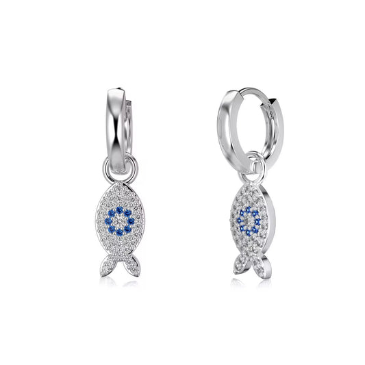 Dos aros con dijes de pez en tono plateado y ojos de piedra azul sobre fondo blanco