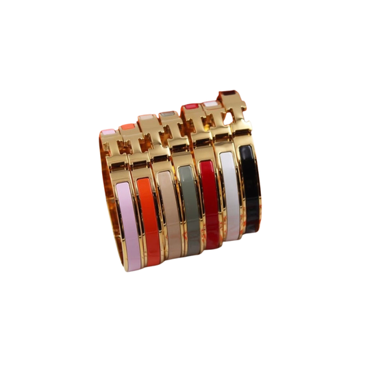 Fila de brazaletes delgados con bordes de tono dorado y bandas de color brillantes en rojo, naranja, gris, verde oliva, beige y rosa