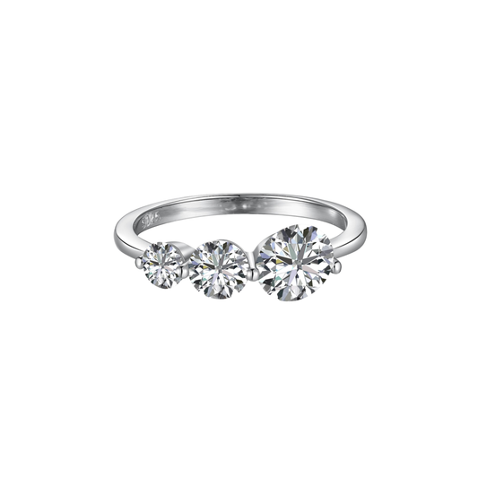 Slim silver-tone ring with three round clear stones increasing in size across the top, on white