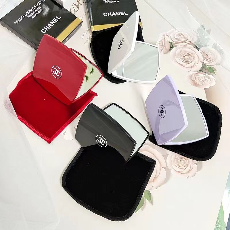 Espejos de bolsillo compactos en rojo, blanco, negro, rosa y lila, algunos abiertos y otros cerrados, con bolsitas negras