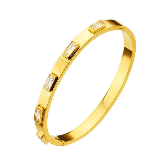 Smooth gold-tone hinged bangle with rectangular clear zircon stones spaced along one side
