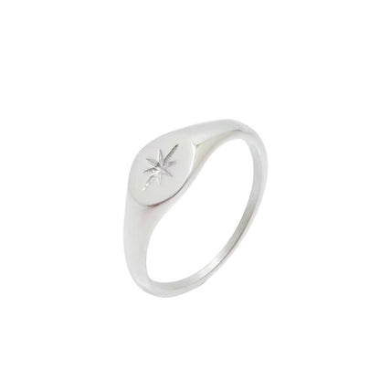 Silver-tone signet-style ring with an oval top engraved with a star, on a white background