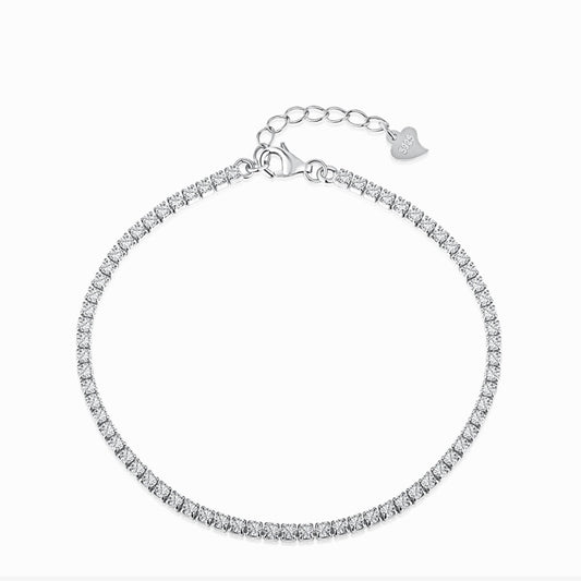 Tennis bracelet with a single row of small clear stones and an extension chain with a heart tag