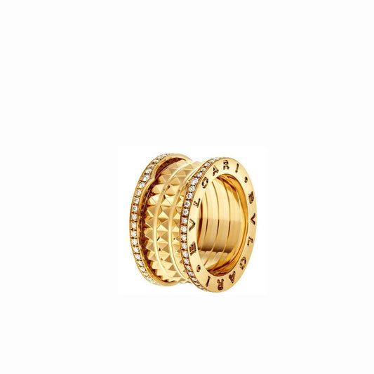 Wide gold-tone barrel-shaped ring with a studded textured section and engraved lettering on the rims