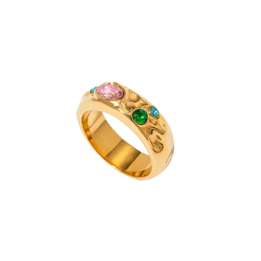 Wide textured gold-colored ring with small pink, green and teal stones, seen from the side