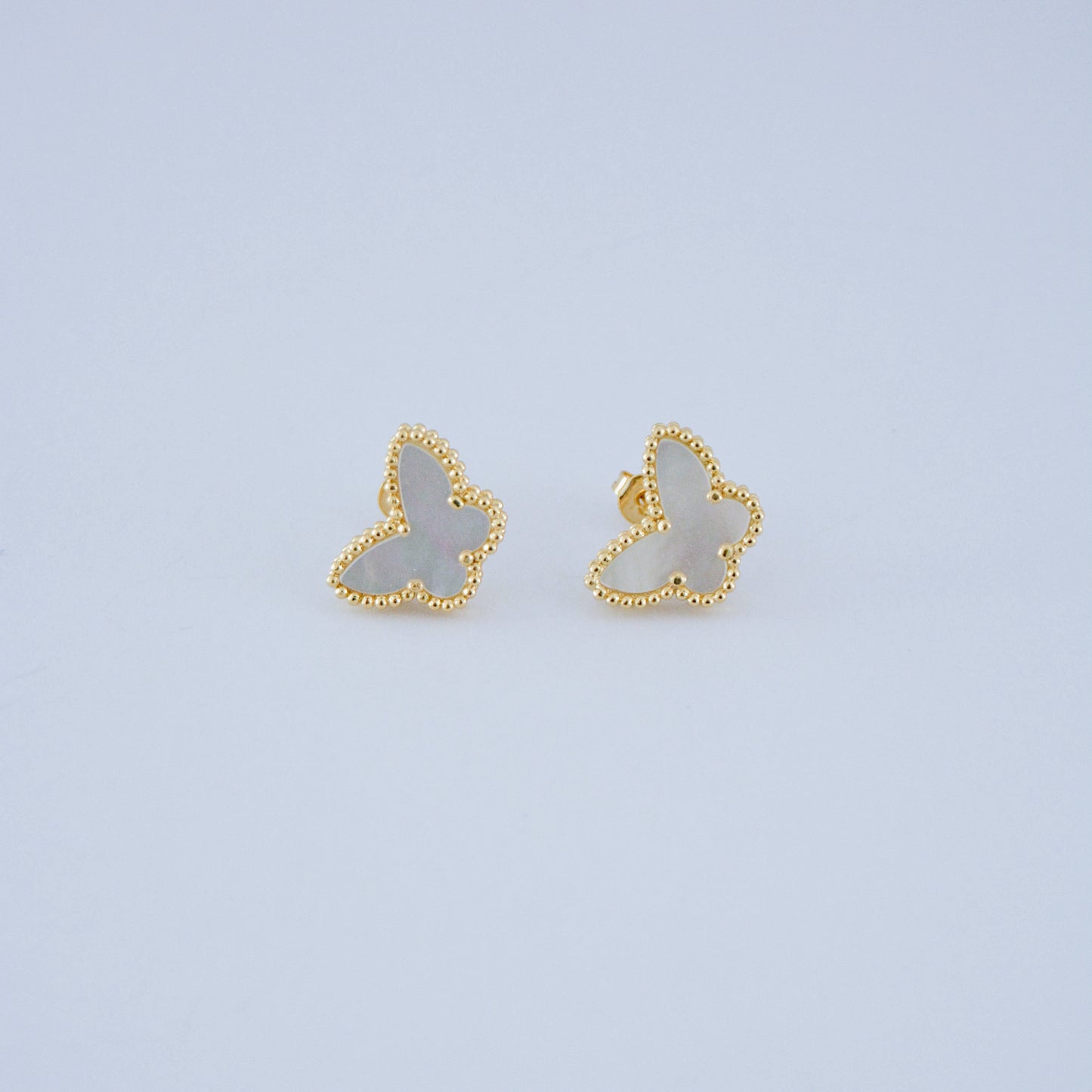 Juego de pendientes estilo trébol de cuatro hojas en oro, con relleno de nácar blanco. Un clásico atemporal de la joyería de lujo.