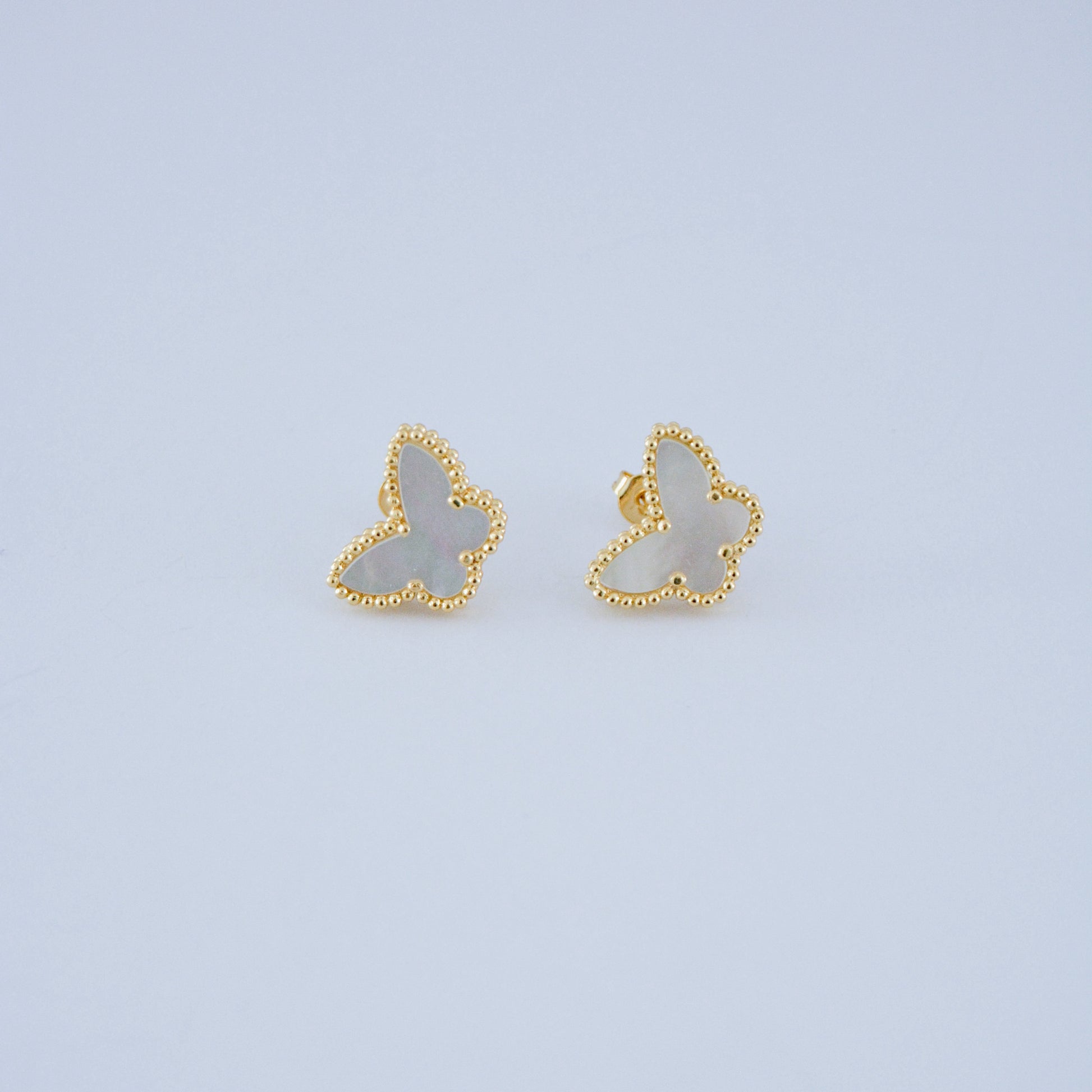 Juego de pendientes estilo trébol de cuatro hojas en oro, con relleno de nácar blanco. Un clásico atemporal de la joyería de lujo.