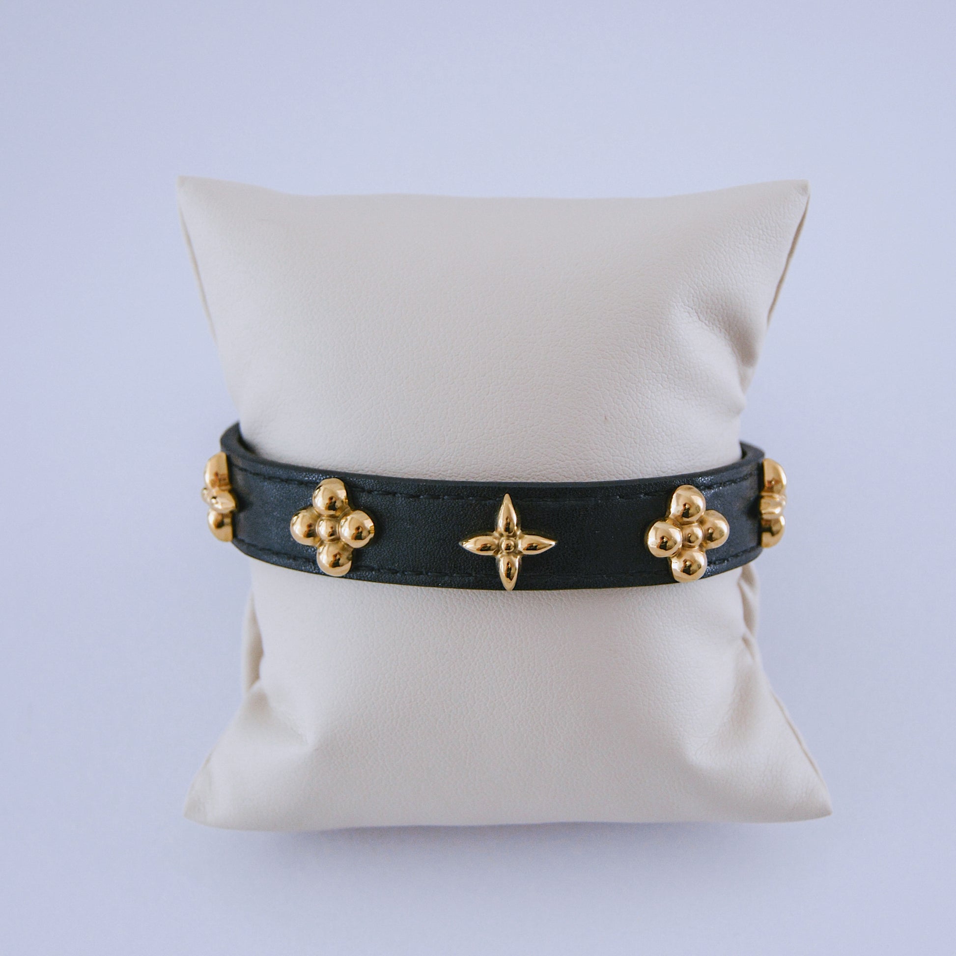 Pulsera de cuero negro con tachuelas y adornos florales dorados. Brazalete de estilo lujoso con cierre ajustable.