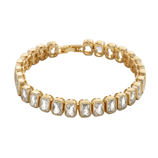 Pulsera tenis de oro con eslabones de piedras de corte esmeralda y cierre de seguridad. Joyería de lujo elegante y atemporal.